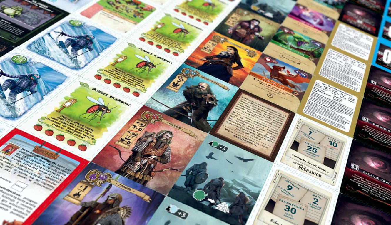 Bliski kadr na kolekcję różnorodnych kart do gry, z ilustracjami postaci fantasy, potworów, elementów magicznych i kart kalendarza.